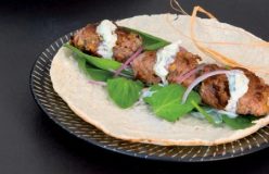 Spiced lamb patties wrapped in pita bread with minted yoghurt sauce
